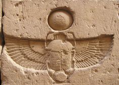 an egyptian bask with wings and scar on it's head, in front of a