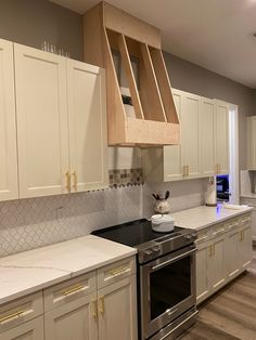 an empty kitchen with white cabinets and stainless steel stove top oven, dishwasher and microwave