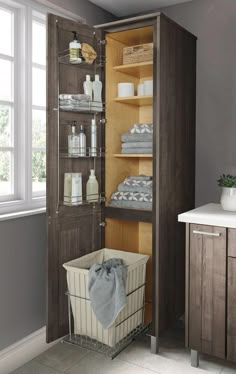 an open cabinet filled with lots of items in a bathroom next to a sink and window