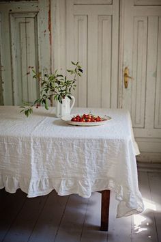 a white table with a bowl of berries on it