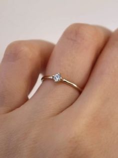 a woman's hand with a diamond ring on top of her finger, showing the side view