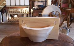 a wooden bowl sitting on top of a table next to a spinning wheel and other items