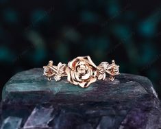 a rose ring sitting on top of a rock