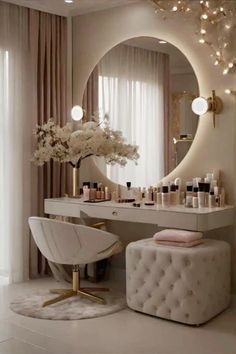 a white vanity and stool in front of a mirror with lights on the wall above it