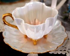 a white and gold coffee cup sitting on top of a saucer