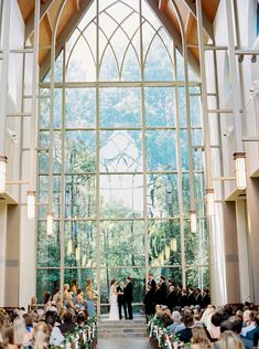 a couple getting married in front of a large window at the end of their wedding ceremony