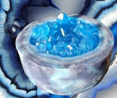 a blue and white object with ice on it's surface in the shape of a bowl