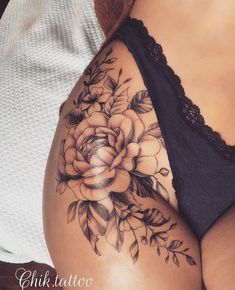 a woman's stomach with flowers and leaves tattooed on the side by chik tattoo