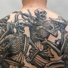 the back of a man's upper body with skeleton tattoos on it and two men riding bikes