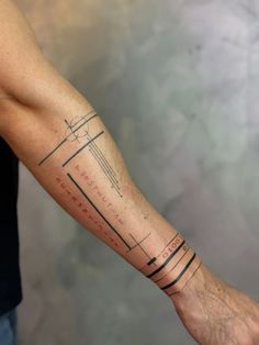 a man's arm with a cross and lines tattoo on the left side of his arm