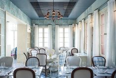 the dining room is set up for an elegant dinner with blue and white wallpaper