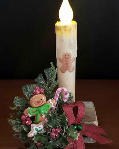 a lit candle sitting on top of a table next to a christmas wreath and candy cane