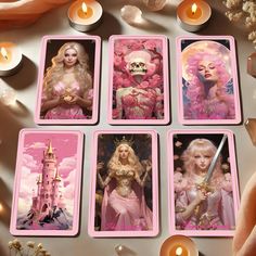 four tarot cards with pictures of barbie dolls on them, surrounded by candles and flowers