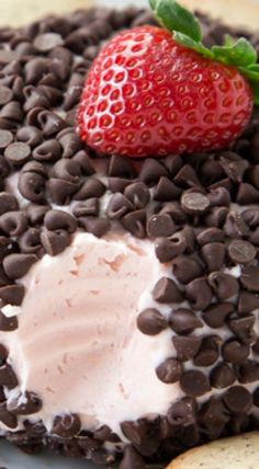 a chocolate covered dessert with a strawberry on top and oreo chips around the edges