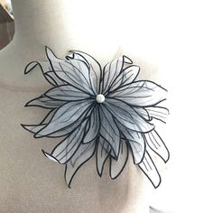 a white and black flower is on a mannequin's neckpieces