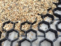 several black hexagonal trays filled with gravel and rocks on the ground next to each other