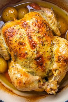 a close up of a chicken in a bowl with olives