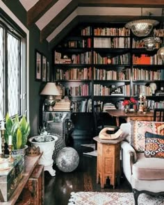 a living room filled with lots of furniture and bookshelves next to a window