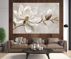 a living room with a couch, coffee table and large flower painting on the wall