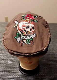 a brown hat with a skull and roses on it