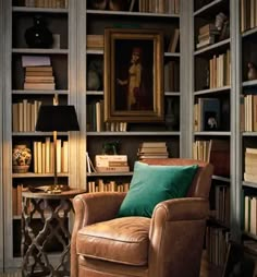 a leather chair sitting in front of a book shelf filled with books