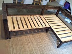 a bed frame made out of wooden slats on the floor in a living room