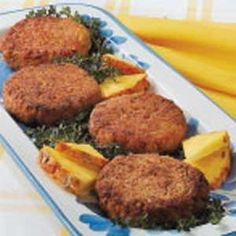 three patties with pineapple and parsley on a blue and white platter