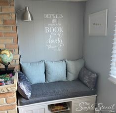 a room with a bench and some books on the shelf next to it is decorated in gray and white