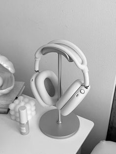 a pair of white headphones sitting on top of a table next to a vase