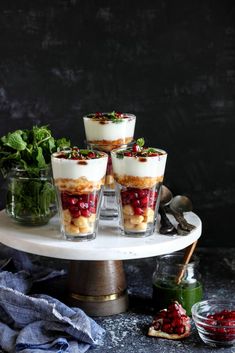 four desserts are arranged on a cake platter, with garnishes