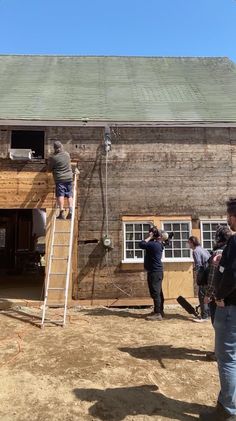 some people are standing on a ladder outside