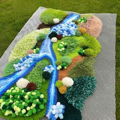 a blanket that is made to look like a river running through the grass and trees