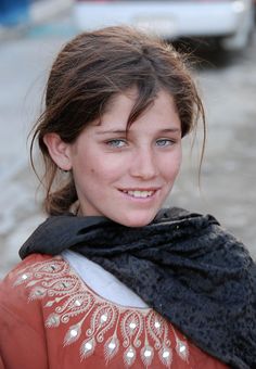 a young woman with blue eyes and a scarf around her neck