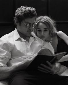 a man reading a book to a woman