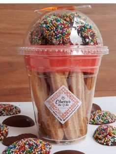 a plastic container filled with chocolate covered pretzels and sprinkles on top of a table