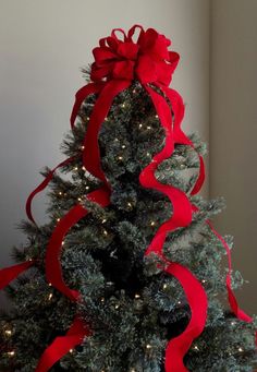 a decorated christmas tree with red ribbon and lights