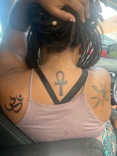 a woman with tattoos on her back sitting in a car