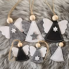 four felt angel ornaments hanging on a fur surface with wooden beads and twinklings