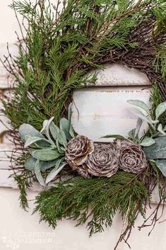 a wreath with pine cones and evergreen leaves