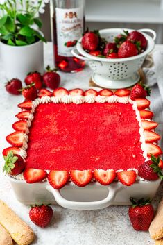 a cake with strawberries in the middle on a table next to other desserts