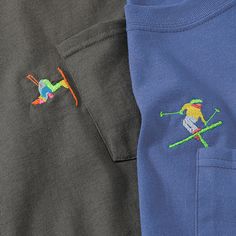 two pairs of polo shirts with embroidered skiers on the front and back, one in blue