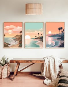 three art prints hanging on the wall above a wooden bench in a room with wood flooring