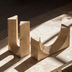 three stone sculptures sitting next to each other on the ground in front of a window