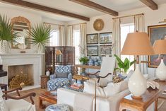 a living room filled with lots of furniture and paintings on the wall next to a fire place