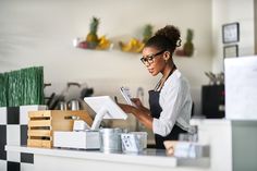 a woman standing at a counter in a store looking at something on her clipboard