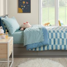 a child's bedroom with blue and white bedding