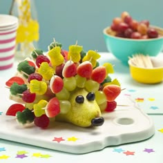 a hedgehog made out of fruit sitting on top of a cutting board