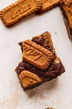 two pieces of brownie with peanut butter frosting on top and one piece cut in half