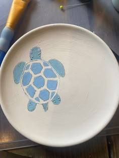 a white plate with a blue turtle painted on it