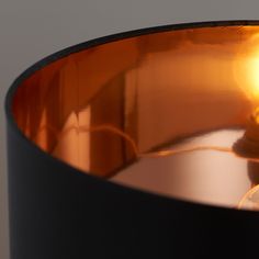 a light that is on top of a metal bowl with an orange light in the middle